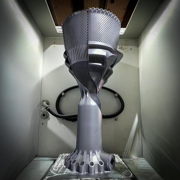 LEAP 71 single-piece 3D printed metal rocket thruster standing in an Eplus3D build chamber