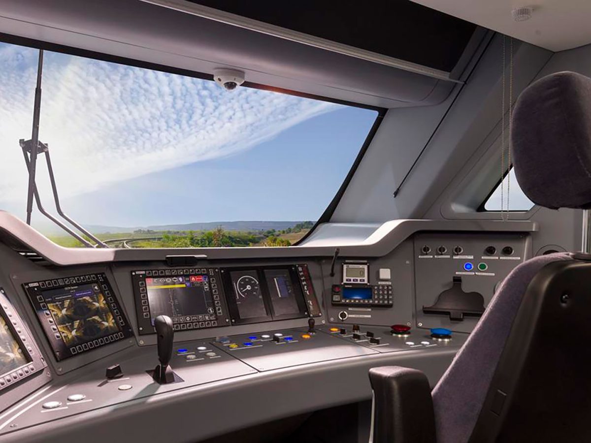 Train driver's cab with control desk, screens and forward view