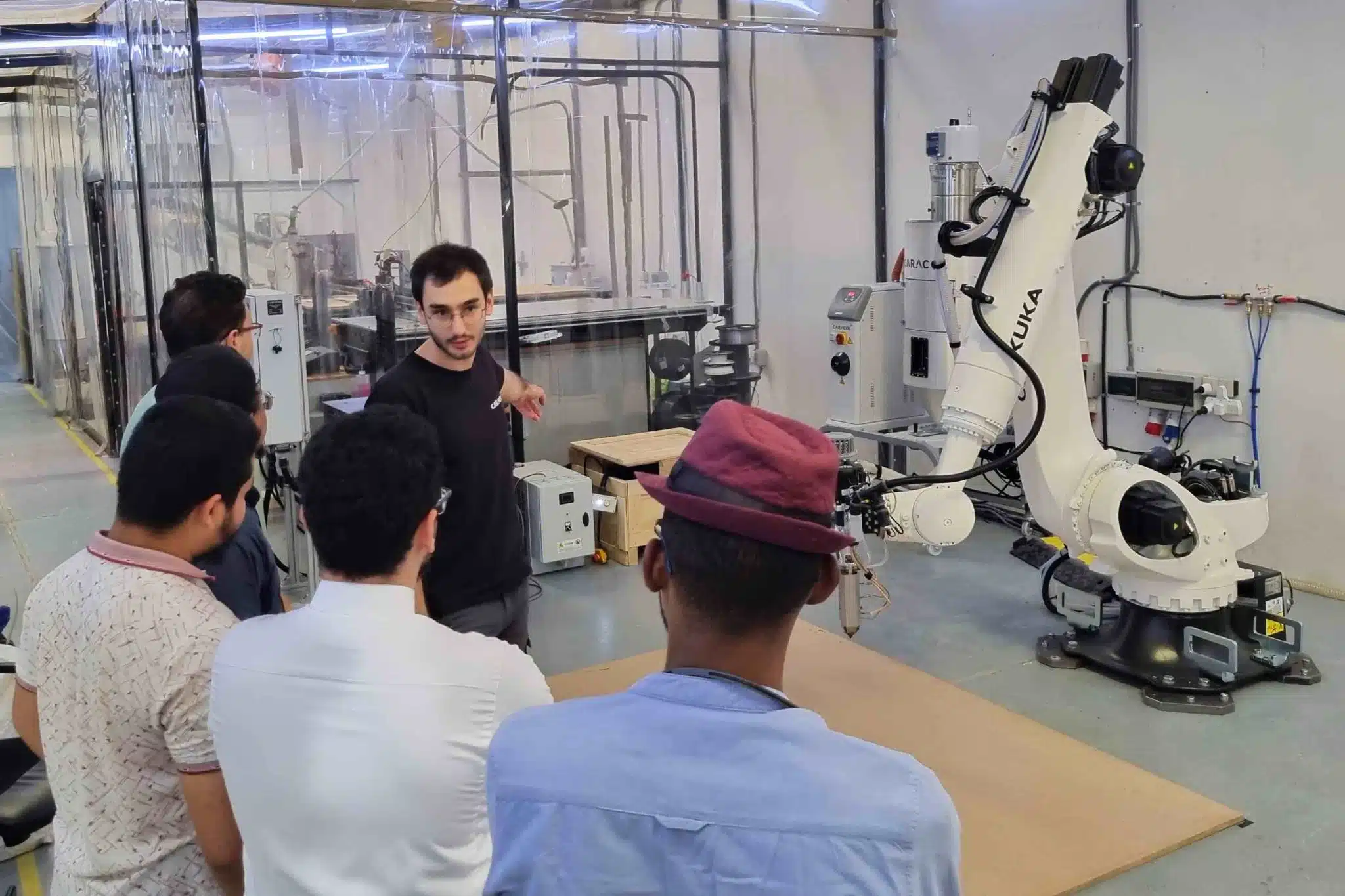 An AM Futures partner engineer leading hands-on training on a robotic large-format 3D printer