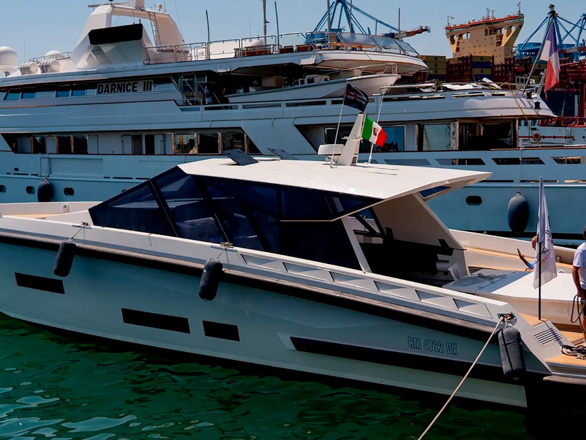Wally-style sports yacht with a dark composite hard-top superstructure